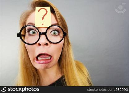 Crazy wondering face expression concept. Wierdo nerd woman having question mark on forehead and geek eyeglasses.. Weirdo nerd woman having question mark on forehead