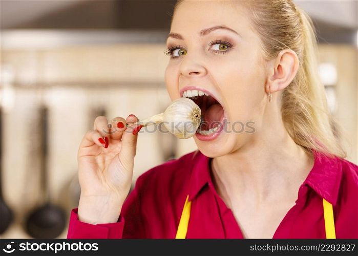 Crazy young woman having fun eating garlic vegetable. Healthy food, fighting disease concept.. Crazy girl eating garlic vegetable