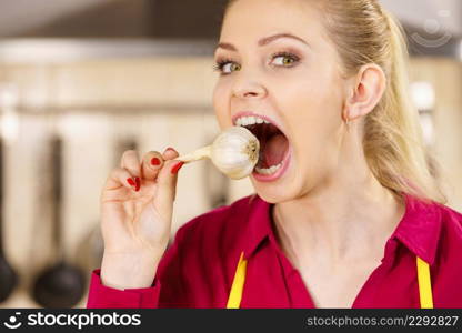 Crazy young woman having fun eating garlic vegetable. Healthy food, fighting disease concept.. Crazy girl eating garlic vegetable