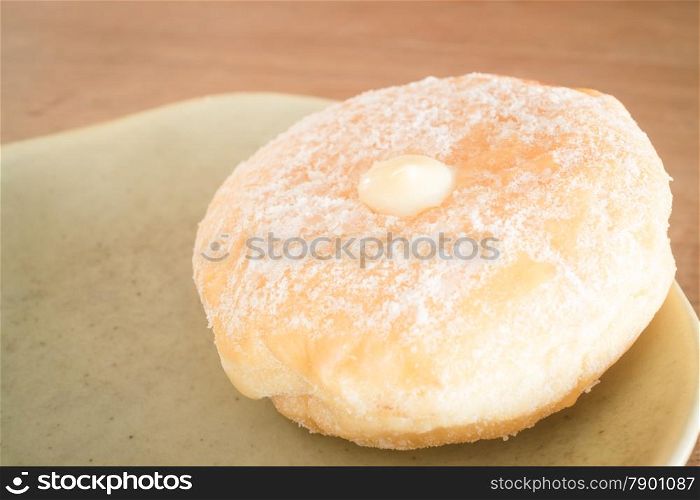 Cream donut on vintage background, stock photo