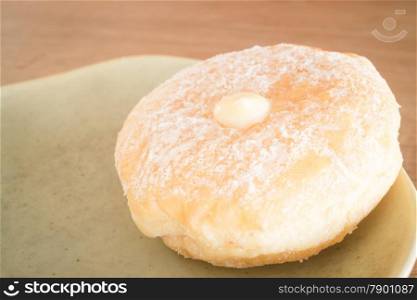 Cream donut on vintage background, stock photo