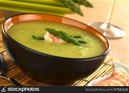 Cream of green asparagus with shrimp (Selective Focus, Focus on the shrimp and the upper asparagus head on the soup). Cream of Asparagus with Shrimp