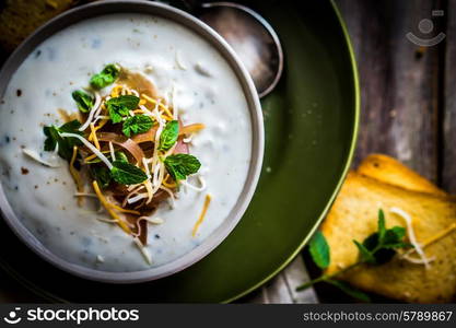 Cream soup with bread and meat on wooden background