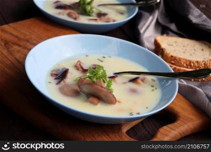 Creamy soup with boletus mushroom and herbs on wooden rustic table .. Creamy soup with boletus mushroom and herbs on wooden rustic table