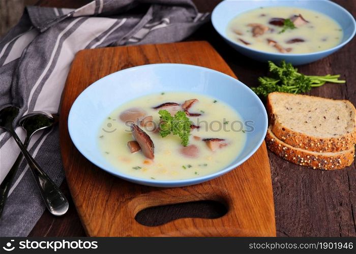 Creamy soup with boletus mushroom and herbs on wooden table .. Creamy soup with boletus mushroom and herbs on wooden table