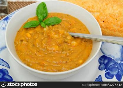 Creamy Vegetable Soup. Hot vegetable soup with a sprig of basil served in a white bowl