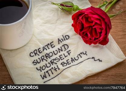 create and surround yourself with beauty - inspirational handwriting on a napkin with a cup of coffee and red rose