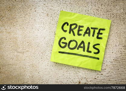 create goals reminder - handwriting on a green sticky note against rustic barn wood