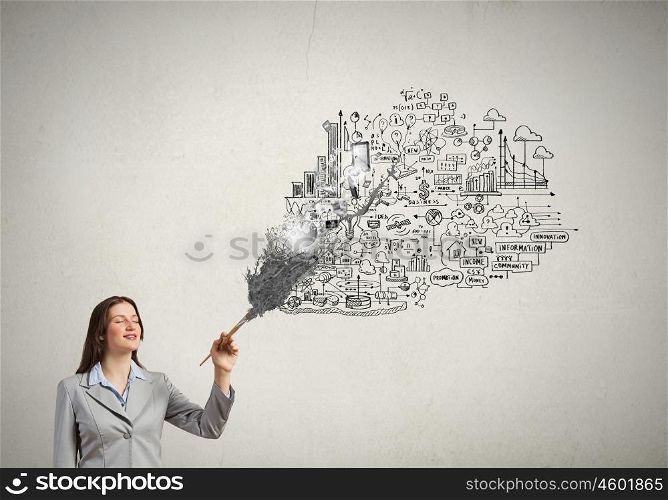 Create your business. Young attractive businesswoman with paint brush and business sketches on wall