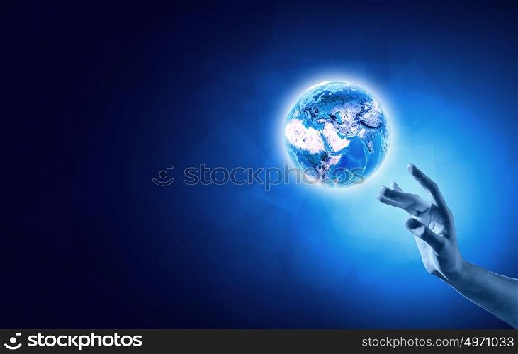 Creation concept. Close up of human hand touching Earth planet with finger. Elements of this image are furnished by NASA
