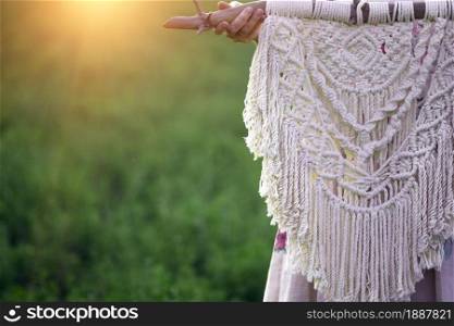 creation of a panel from macrame. girl with macram panel in the sunset field