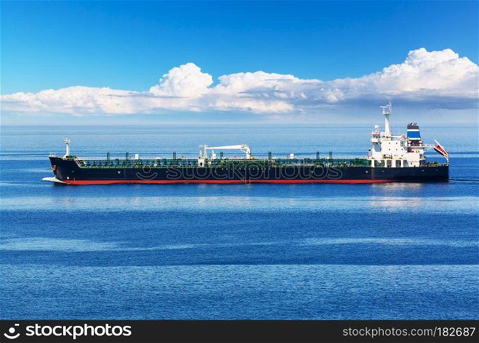Creative abstract oil and gas industry and sea transportation, shipping and logistics business trading commerce concept: industrial oil and chemical commercial tanker ship vessel in blue ocean