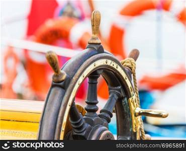 Creative abstract sea navigation, travel, tourism and ocean adventure concept: macro view of the wooden steering wheel on sailing ship