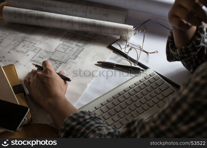 Creative architect projecting on the big drawings in the dark loft office or cafe with dark and retro style.