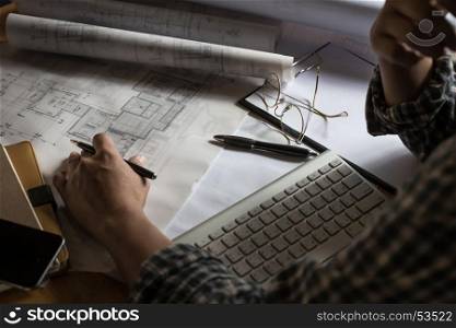 Creative architect projecting on the big drawings in the dark loft office or cafe with dark and retro style.