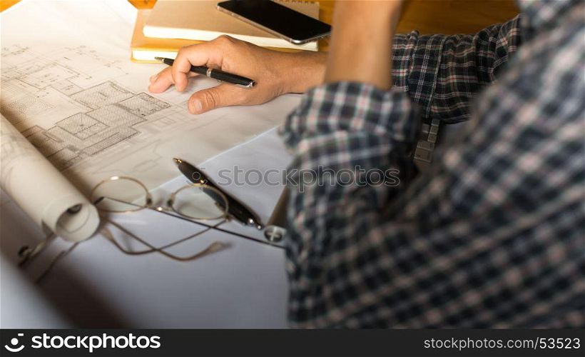 Creative architect projecting on the big drawings in the dark loft office or cafe with dark and retro style.