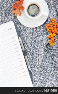 Creative autumn flat lay overhead top view stylish home workspace with planner organizer coffee cup cozy gray knitted plaid background copy space. Fall season template for feminine blog social media