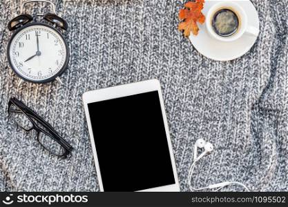 Creative autumn flat lay overhead top view stylish home workspace with tablet notebook coffee cup cozy gray knitted plaid background copy space. Fall season template for feminine blog social media