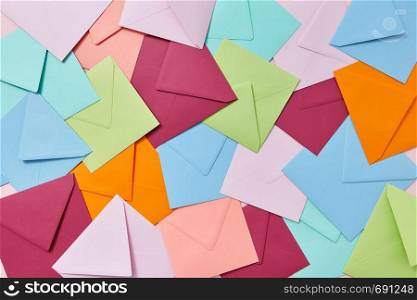 Creative background from handcraft colored blank envelopes and letters.. Multi colored craft envelopes pattern as a background.
