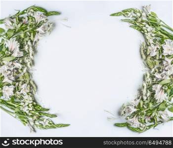 Creative beautiful floral frame layout with green flowers, petals and leaves on white background, top view