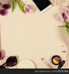 Creative beauty feminine arrangement of flowers and cosmetics. Flat lay. Pink background. Top view