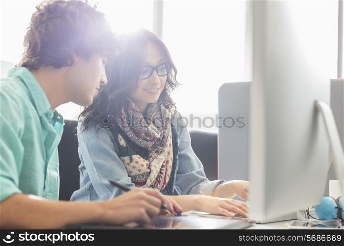 Creative business colleagues using desktop computer in office
