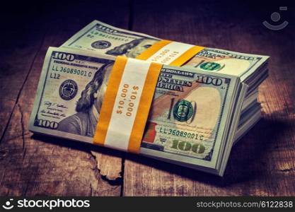 Creative business finance making money concept. Vintage retro effect filtered hipster style image of stacks of new 100 US dollars 2013 edition banknotes bills bundles isolated on wooden background. Stacks of new 100 US dollars 2013 banknotes