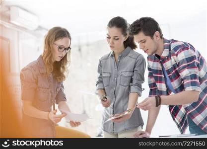 Creative business people looking at photographs in office