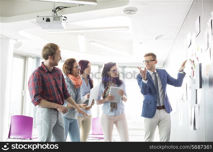 Creative businessman giving presentation to colleagues in office