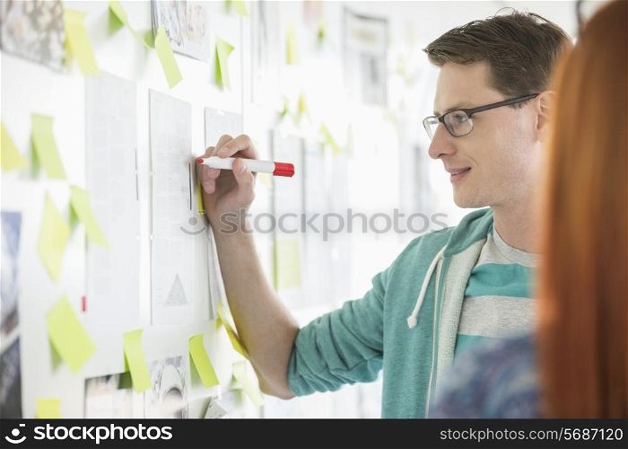 Creative businessman writing notes on paper in office