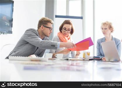 Creative businesspeople analyzing documents at desk in office