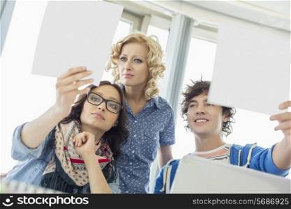 Creative businesspeople analyzing photographs in office