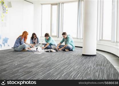 Creative businesspeople working on floor in office