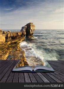 Creative concept image of seascape landscape coming out of pages in magical book
