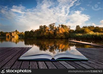 Creative concept image of sunset sky reflected in Autumn Fall lake in pages of book