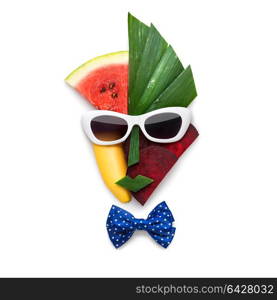 Creative concept of cubist style female face in sunglasses made of fruits and vegetables, on white background.