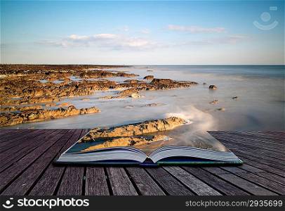Creative concept pages of book Landscape image of rocky beach at susnet with long exposure motion blur sea