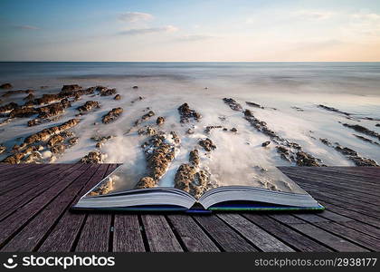 Creative concept pages of book Landscape image of rocky beach at susnet with long exposure motion blur sea