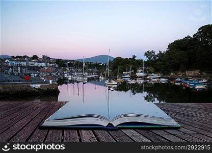 Creative concept pages of book Sunset reflections of boats in harbour in Summer