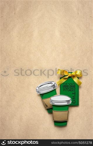 Creative concept photo of a cup of coffee made of paper on brown background.