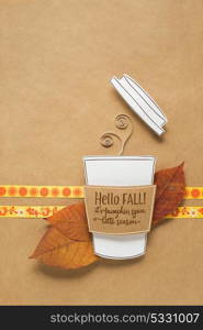 Creative concept photo of a cup of coffee made of paper on brown background.