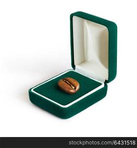 Creative concept photo of a jewelry box with a coffee bean on white background.