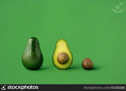 Creative concept photo of avocados on green background.