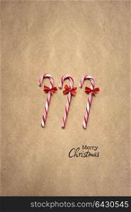 Creative concept photo of christmas lollypop candies on brown background.