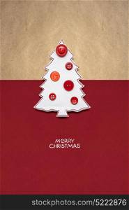 Creative concept photo of christmas tree made of paper and buttons on red brown background.