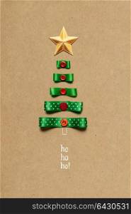 Creative concept photo of christmas tree made of ribbon on brown background.