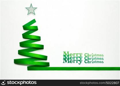 Creative concept photo of christmas tree made of ribbon on white background.