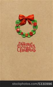 Creative concept photo of christmas wreath made of buttons on brown background.