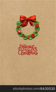 Creative concept photo of christmas wreath made of buttons on brown background.