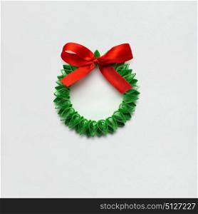 Creative concept photo of christmas wreath made of quilling paper on white background.